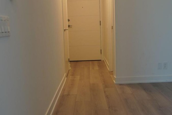 Apartment entrance hallway with light wood laminate flooring and white doors. - 819 - 20 Deans Drive, Toronto