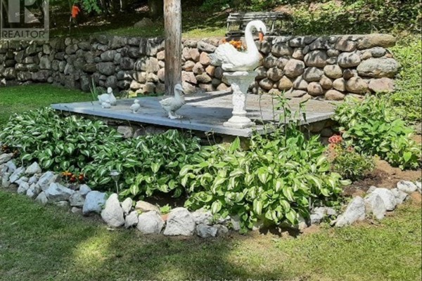 Yard with stone wall, platform, swan statue, goose statues - 82 Bay Lake Road Bancroft