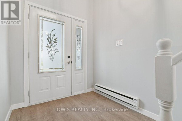 Interior entryway with double doors featuring frosted glass panels and light grey walls. - 82 Bertha Street, Champlain