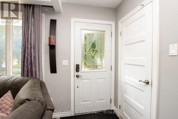 Interior view of the front entrance with a white door featuring decorative glass and a grey wall. - 82 Langton Road, London East