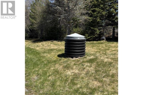 Round black corrugated pipe structure with a white lid sitting in a grassy field. - 82 Mobile First Pond Road, Mobile