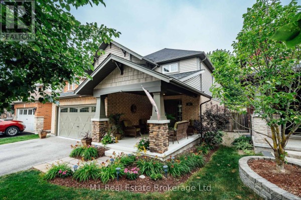 Side view of the house exterior showing the garage, porch, and landscaping. - 82 Vaughan Street, Guelph
