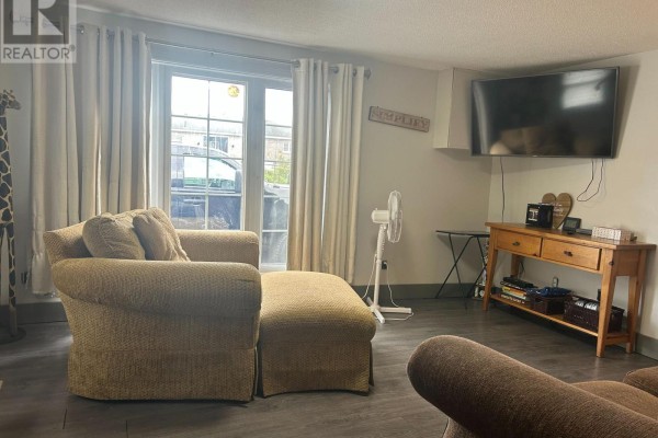 Living room with beige furniture, a television mounted on the wall, and a wooden console table. - 820 Line 11 Line N, Oro Medonte