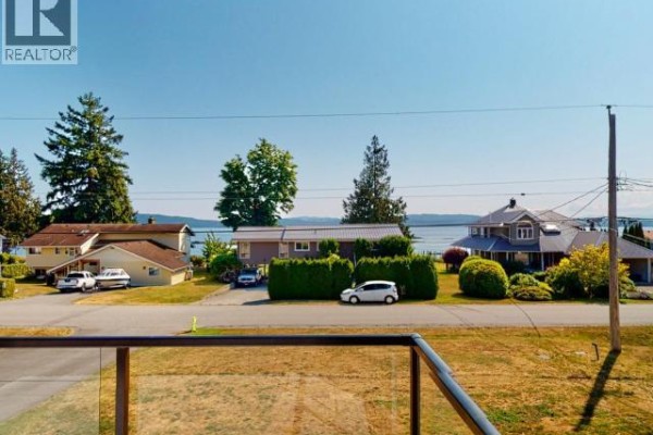 Laundry room featuring two freezers, shelving, and cleaning supplies. - 8206 Centennial Drive, Powell River