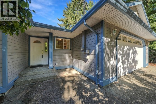 Close-up of the front entrance with a white door and a window, next to the garage. - 821 Shorewood Dr, Parksville