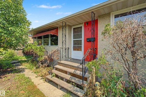 Close-up of the front entrance with wooden steps and a red door. - 8215 149 Street Nw, Edmonton