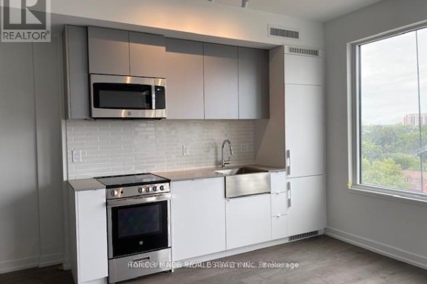 Modern kitchen with white and grey cabinetry, stainless steel appliances, and subway tile backsplash. - 822 - 270 Dufferin Street, Toronto