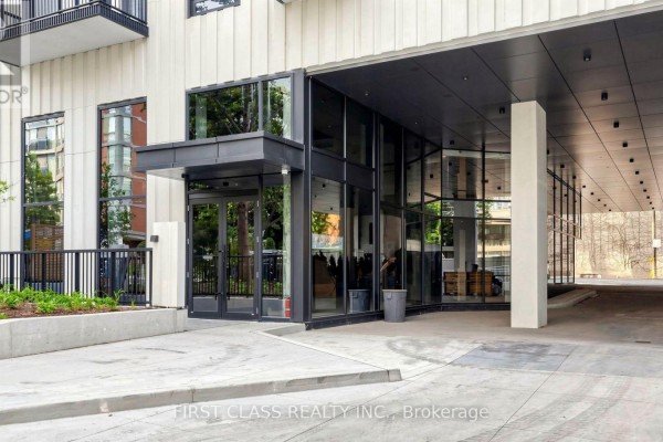 Open concept living area with dark wood floors and a minimalist kitchen. - 822 - 91 Montclair Avenue, Toronto