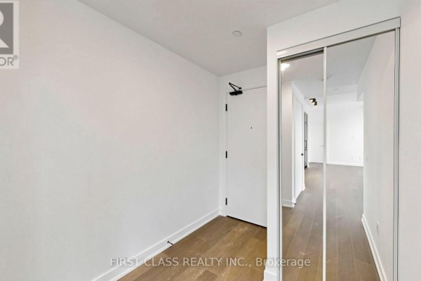 Living room with dark wood floors, large windows, and access to balcony. - 822 - 91 Montclair Avenue, Toronto