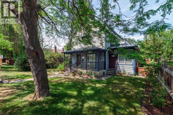 Side aerial view of the property, focusing on the back of the house and adjacent structures. - 822 Lawrence Avenue, Kelowna