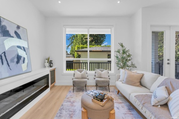 Living room with a white sofa, two accent chairs, and a fireplace with a large window. - 8221 111b Street, Delta