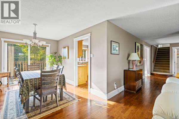 Aerial view of a multi-level home with a backyard gazebo, deck, and distant ocean view. - 823 Glenhale Cres, Parksville