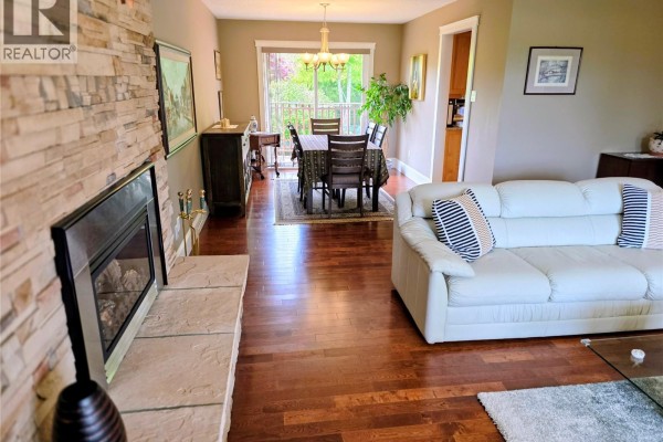 Exterior of a grey stucco and brick house with a double garage and paved driveway. - 823 Glenhale Cres, Parksville