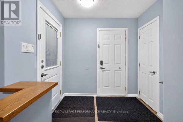 Foyer of the townhouse showing multiple doors and light blue walls. - 823 Nesting Way, Ottawa