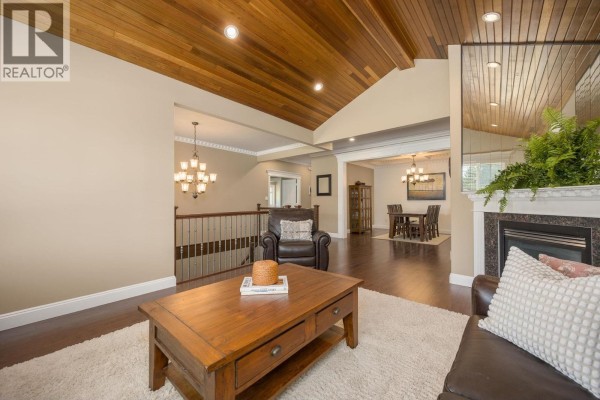 Living room with fireplace and view of the dining room and staircase. - 825 Robinson Street, Coquitlam
