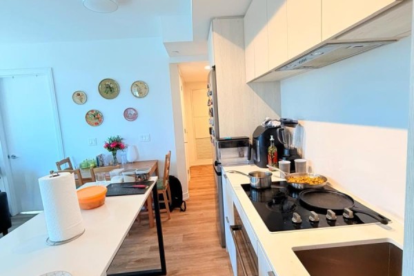 Kitchen with white cabinets, stainless steel appliances, a stovetop, and an adjacent dining area. - 827 - 1 Jarvis Street, Hamilton