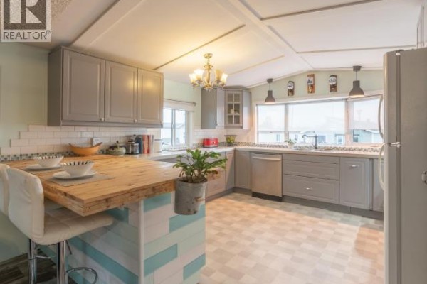 Kitchen with light gray cabinets, white countertops, stainless steel appliances, and a patterned floor. - 828 Dusseault, Yellowknife
