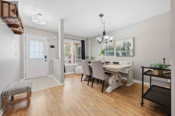 Dining area with a light wood table, grey chairs, and laminate flooring. - 828 Taggart Crescent, Oshawa