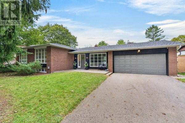 Exterior view of a brick bungalow with a gray garage door and driveway. - 829 Terlin Boulevard, Mississauga