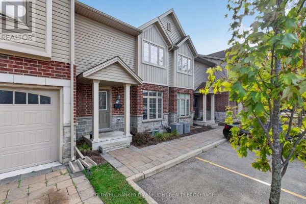 Close-up of a townhouse entrance with stone accents, a covered porch, and a paved walkway. - 83 - 1061 Eagletrace Drive, London North