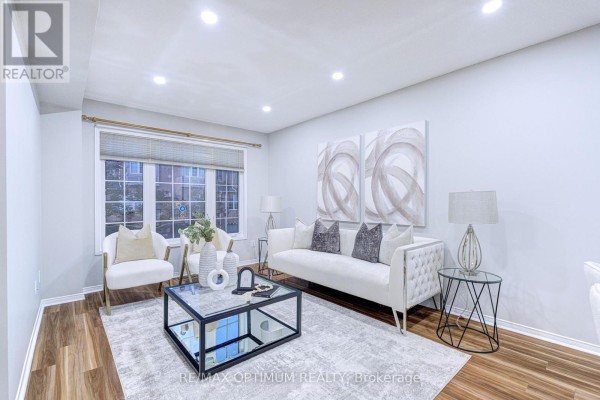 Living room with a white tufted sofa, two accent chairs, a glass coffee table, and artwork. - 83 - 5030 Heatherleigh Avenue, Mississauga