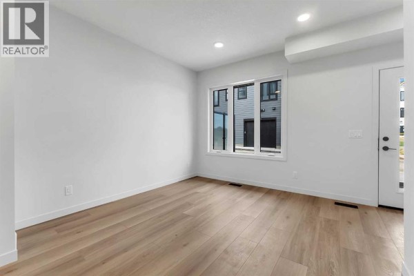 Another view of the living area with white walls and light wood flooring. - 83 Arbour Lake Court Nw, Calgary
