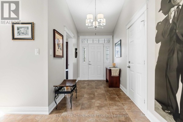 Bright and spacious entrance hall with tiled floor, chandelier, bench, and double front doors. - 83 Blackshire Circle, Ottawa
