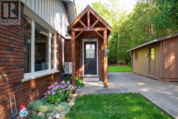 Entrance porch with a black door, wooden beams, and a small shed to the right. - 83 Boulton Street, South Bruce Peninsula