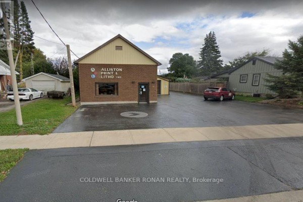 Exterior view of a brick commercial building at 83 Dufferin Street with a paved parking lot and signage. - 83 Dufferin Street, New Tecumseth