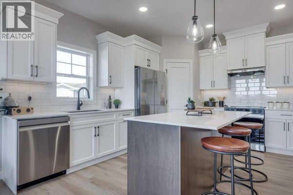 Kitchen with white shaker cabinets, quartz countertops, subway tile backsplash, and stainless steel dishwasher. - 83 Gray Close, Sylvan Lake