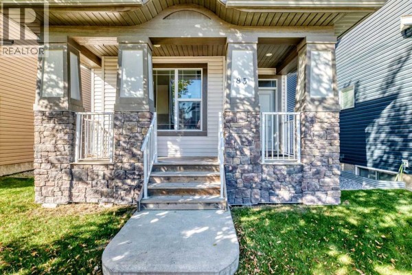 Close-up of the house entrance with stairs leading to a covered porch with stone pillars. - 83 Legacy Crescent Se, Calgary