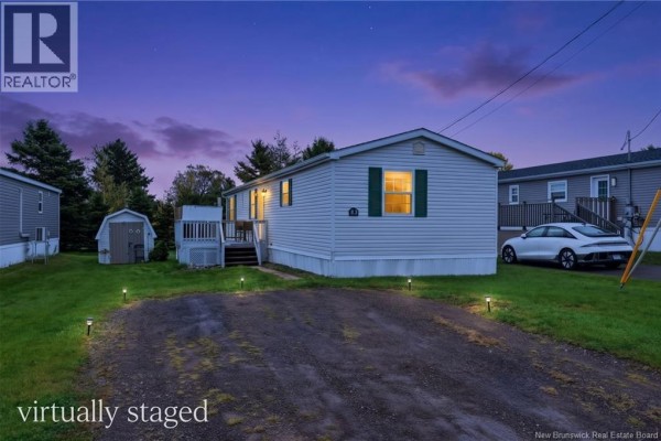 Exterior of a single-family home at dusk, illuminated by exterior lights and interior lights. - 83 Louisbourg Street, Shediac