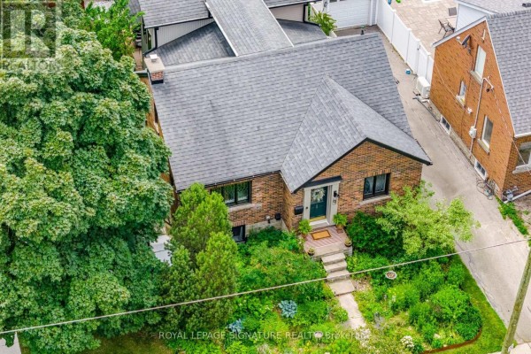 Aerial view of a brick house surrounded by mature trees and landscaping. - 83 Mill Street S, Brampton