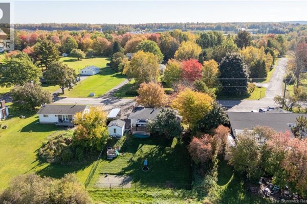 Aerial view of 83 Renfrew property with neighboring houses and colorful autumn trees. - 83 Renfrew, Petitcodiac
