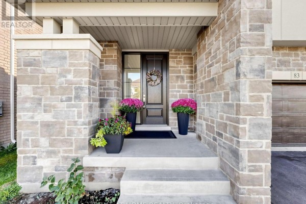 Close-up of the house entrance with stone pillars, concrete steps, and potted flowers. - 83 Vasey Road, Bradford West Gwillimbury
