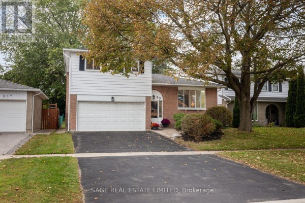 Front exterior of brick and white siding house with attached garage and driveway. - 83 Waverley Road, Clarington