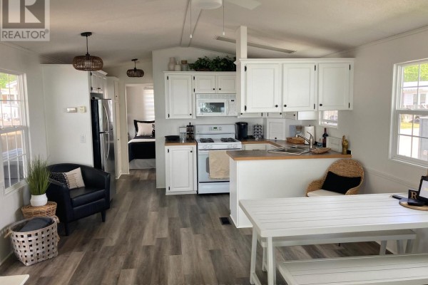 Open-concept kitchen with white cabinets and a view into a bedroom. - 83 Wyldewood, Port Colborne