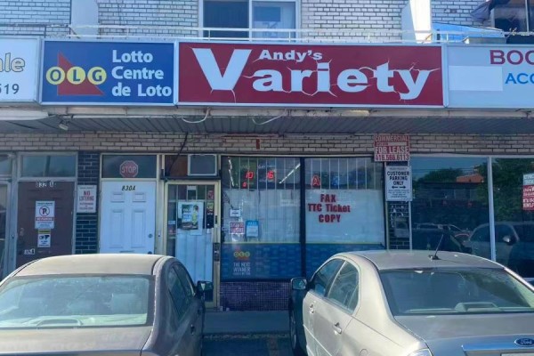Exterior storefront of Andy's Variety, a convenience store with multiple businesses and parked cars. - 830 Wilson Avenue, Toronto