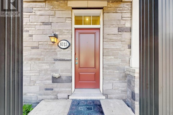 Close-up of a red front door with address 8313, set against a stone facade and covered porch. - 8313 Islington Avenue, Vaughan
