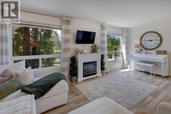 Foyer with a white upright piano, bench, large clock, and front door with glass panels. - 8320 Centre Street Ne, Calgary