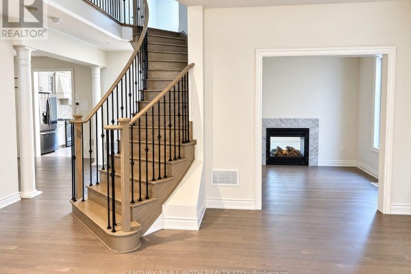 Bright, open-concept living space with a beige sofa, large windows, and adjacent dining area and kitchen. - 833 Langford Boulevard, Bradford West Gwillimbury