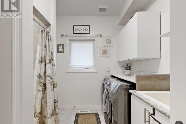 Bathroom vanity with mirror and wood-grain cabinets, door to office - 833 Langford Boulevard Bradford West Gwillimbury