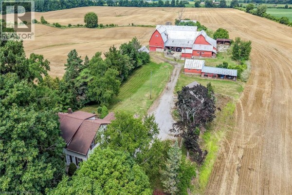 Aerial view of a house, red barn, farm buildings, and surrounding fields. - 833 Lynn Valley Road, Port Dover