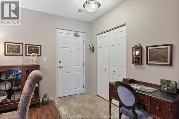 Entranceway to a unit with a white door, double closet doors, desk, and display cabinet. - 8335 Wyandotte Street East Unit# 108, Windsor