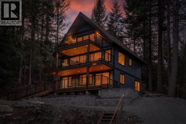 Exterior view of a dark blue mountain home with large windows and decks. - 8353 Rainbow Drive, Whistler