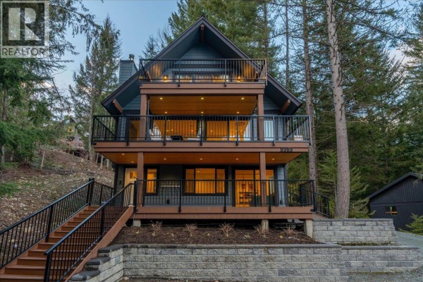 Front view of a multi-level home with dark siding, wood trim, and decks. - 8353 Rainbow Drive, Whistler