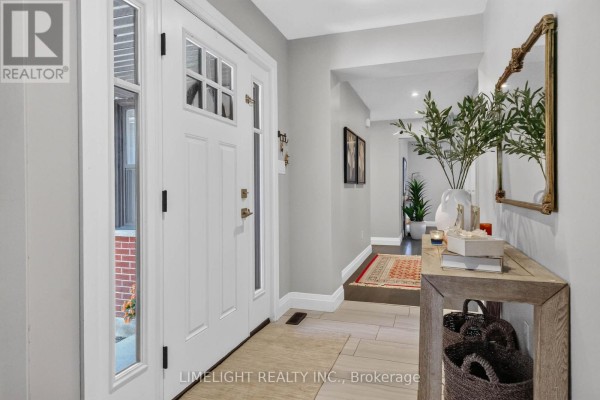 Interior view of a bright entryway with a white double door, light grey walls, and a console table. - 836 Manchester Road, London North