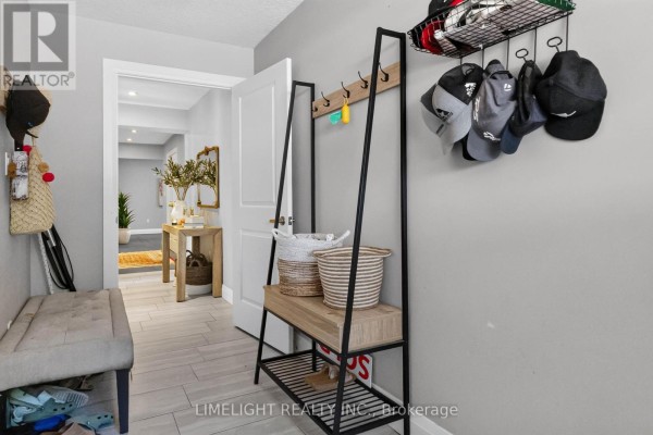 View of an entryway with a bench, storage rack with hats, and a hallway leading to the main living area. - 836 Manchester Road, London North