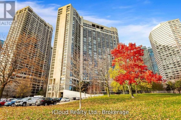 Exterior view of 33 Harbour Square tower with surrounding trees and parked cars. - 837 - 33 Harbour Square, Toronto