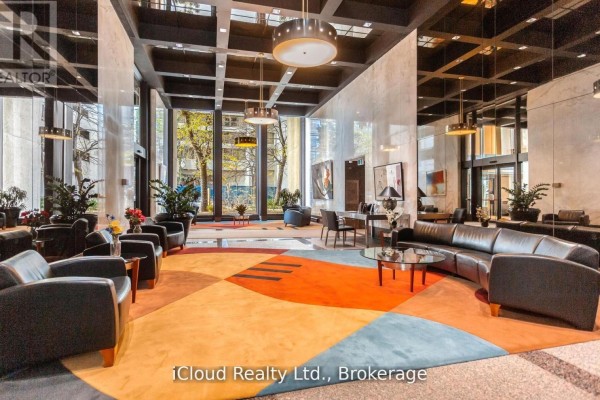 Lobby seating area with black leather sofas, glass coffee tables, and a colorful carpet. - 837 - 33 Harbour Square, Toronto